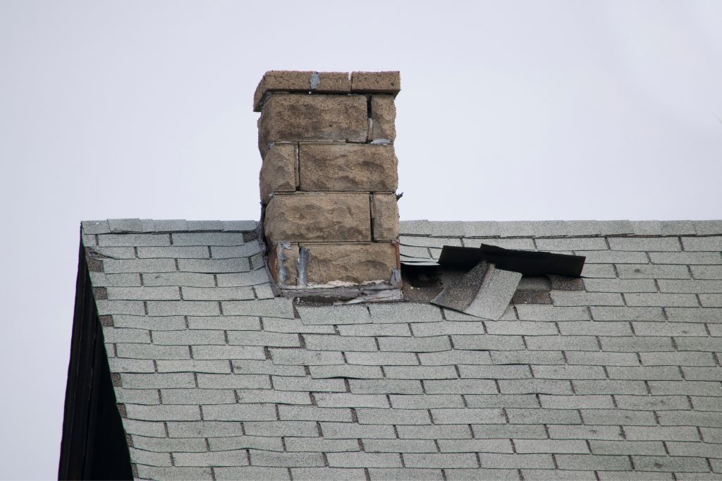 Roofing repair job next to a chimney