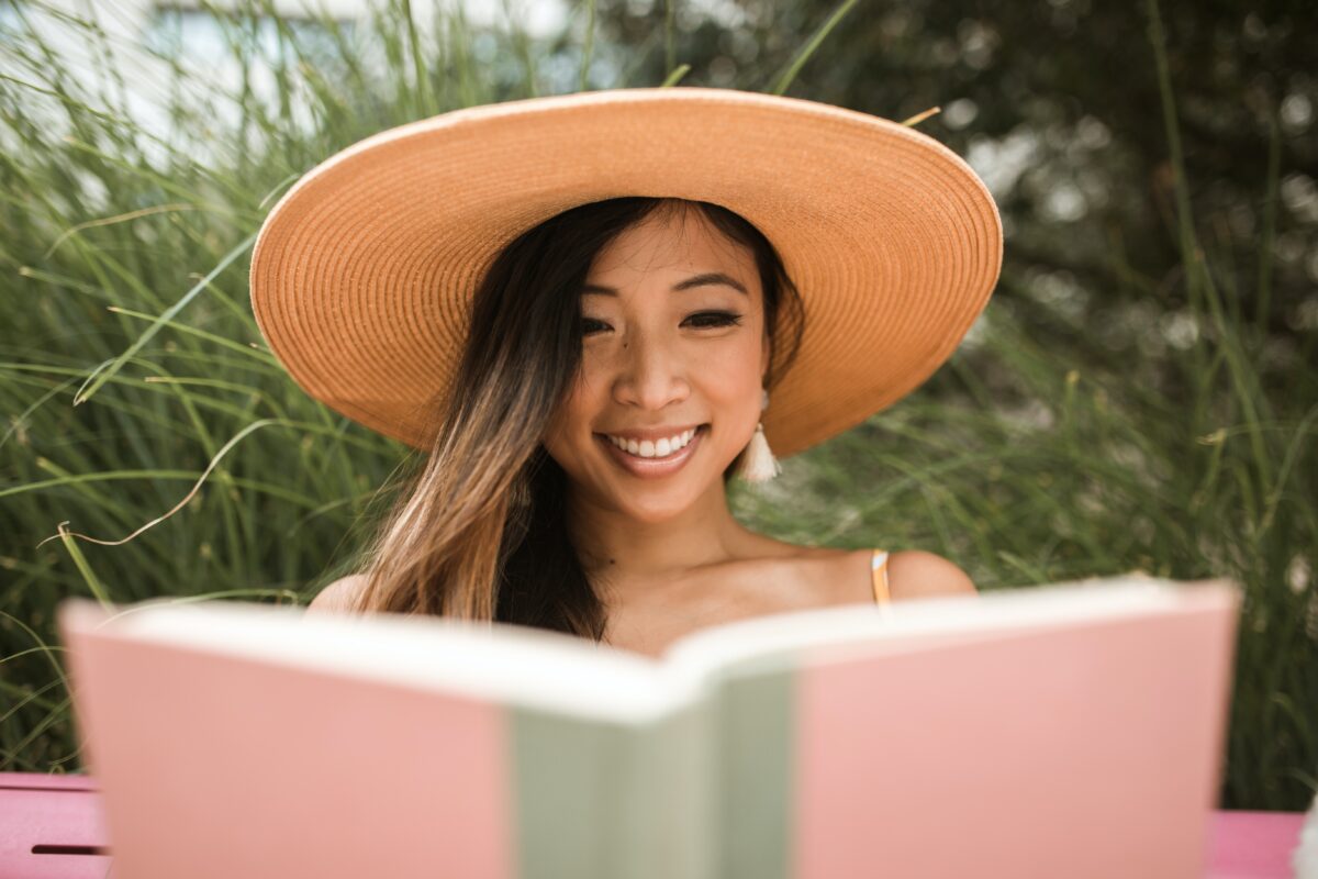 A woman in a sun hat reading a book for contractors