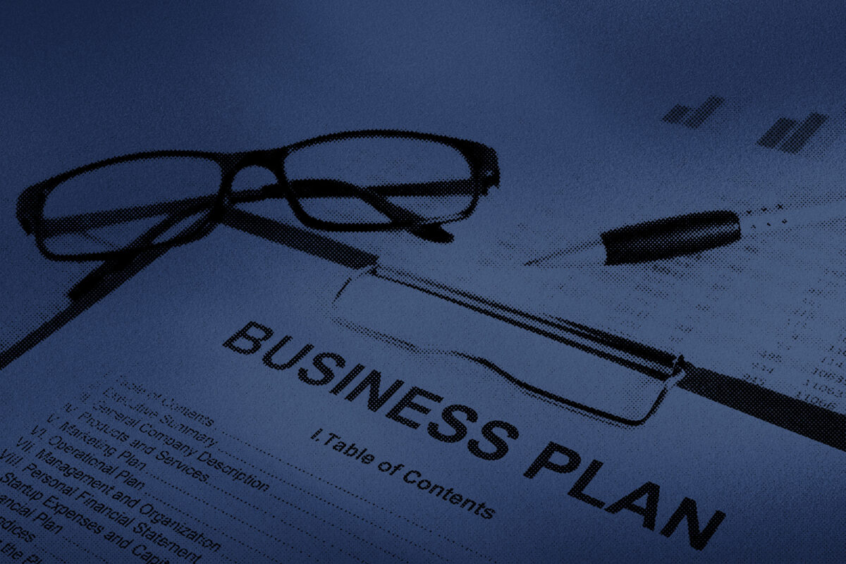 Roofing business plan printed out on a clipboard with glasses and a pen