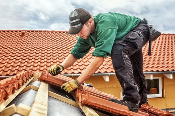 roofer using gloves while working on a tile roof